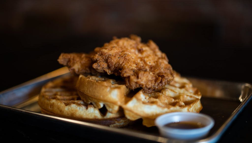 chicken and waffles on an aluminum tray