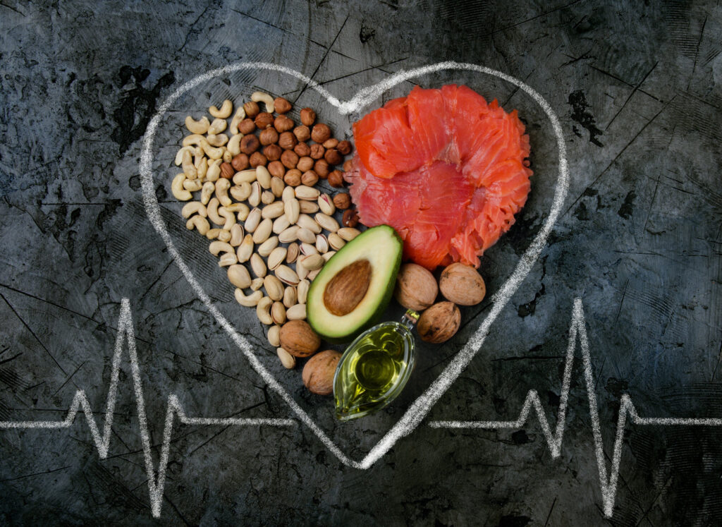 Heart-healthy foods including salmon, nuts, avocado and extra-virgin olive oil inside a hand-drawn heart