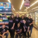 Group of people inside a grocery store wearing Making Strides Against Breast Cancer shirts