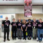 People inside a grocery store wearing matching Making Strides Against Breast Cancer T-shirts