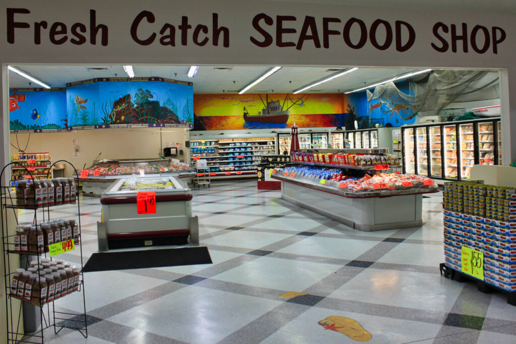 Grocery store seafood market with signage reading “Fresh Catch Seafood Shop”