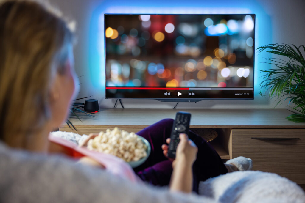 Woman watching TV and eating popcorn