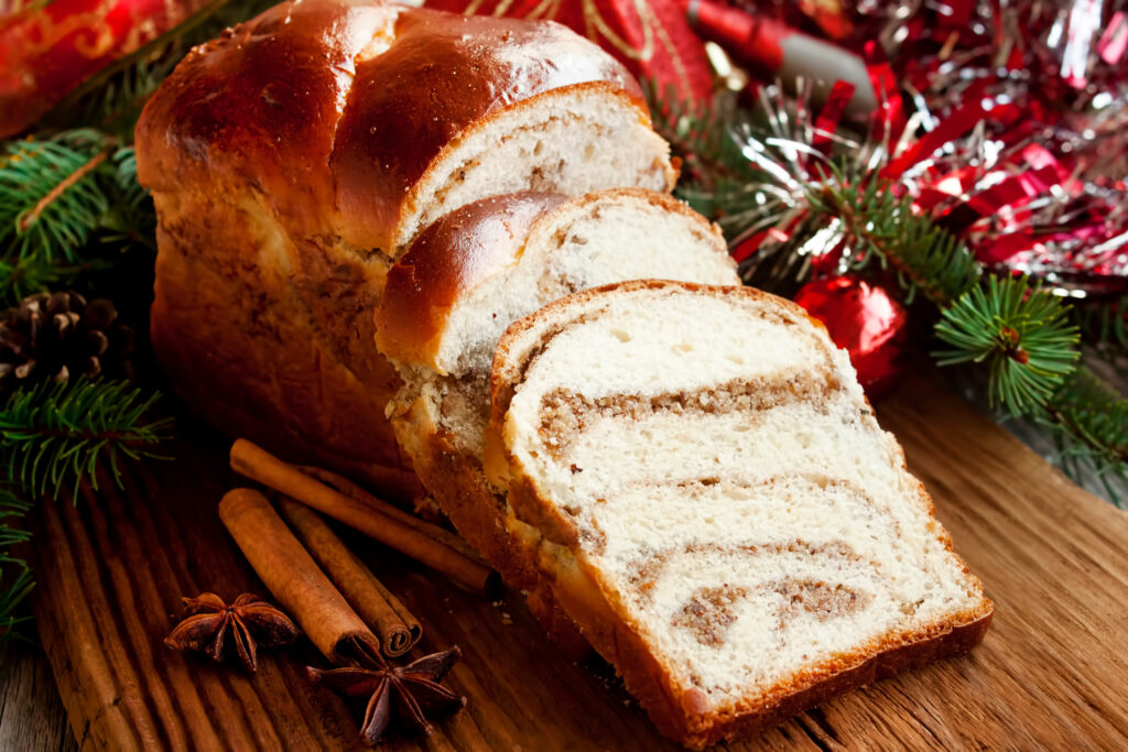 cinnamon swirl bread on a table with tinsel, pine boughs and cinnamon sticks