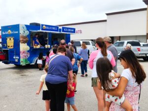 People in line at a Blue Bell ice cream truck