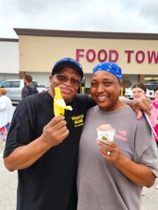 Man and woman holding Blue Bell treats in front of Food Town grocery store