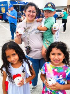 Woman with three children holding ice cream outside a Blue Bell ice cream truck