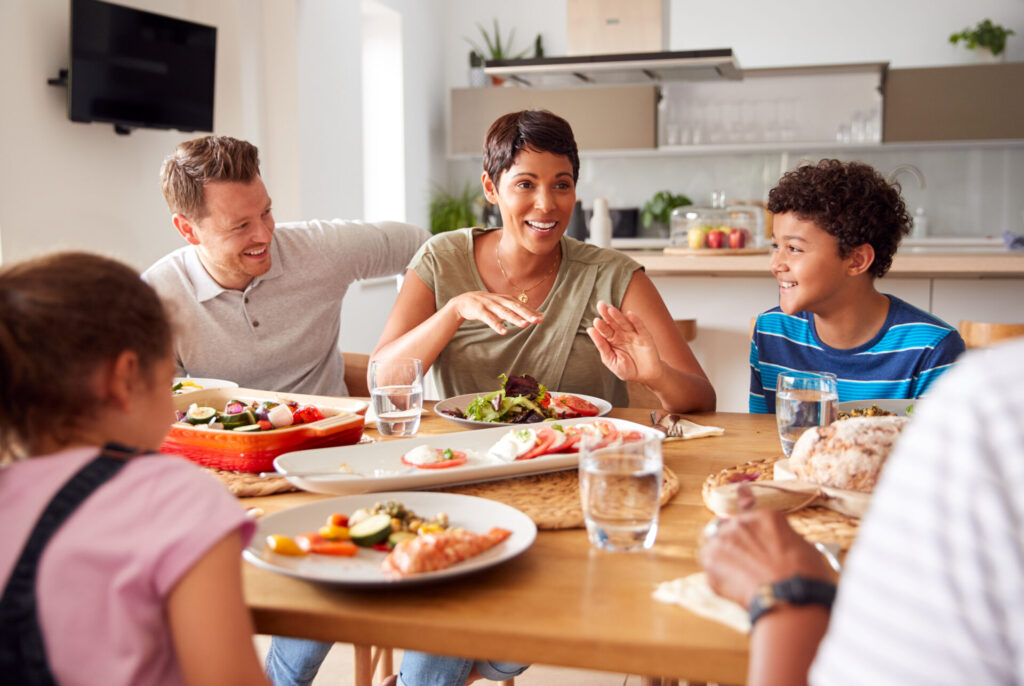 Woman telling story to husband and children around the dinner table