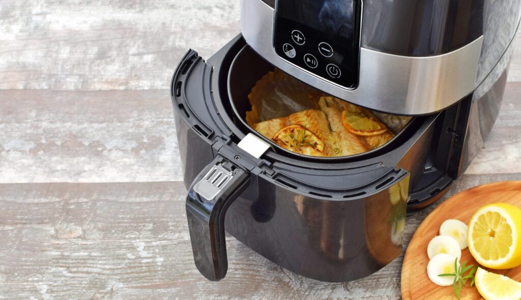 Air fryer filled with fish and lemons
